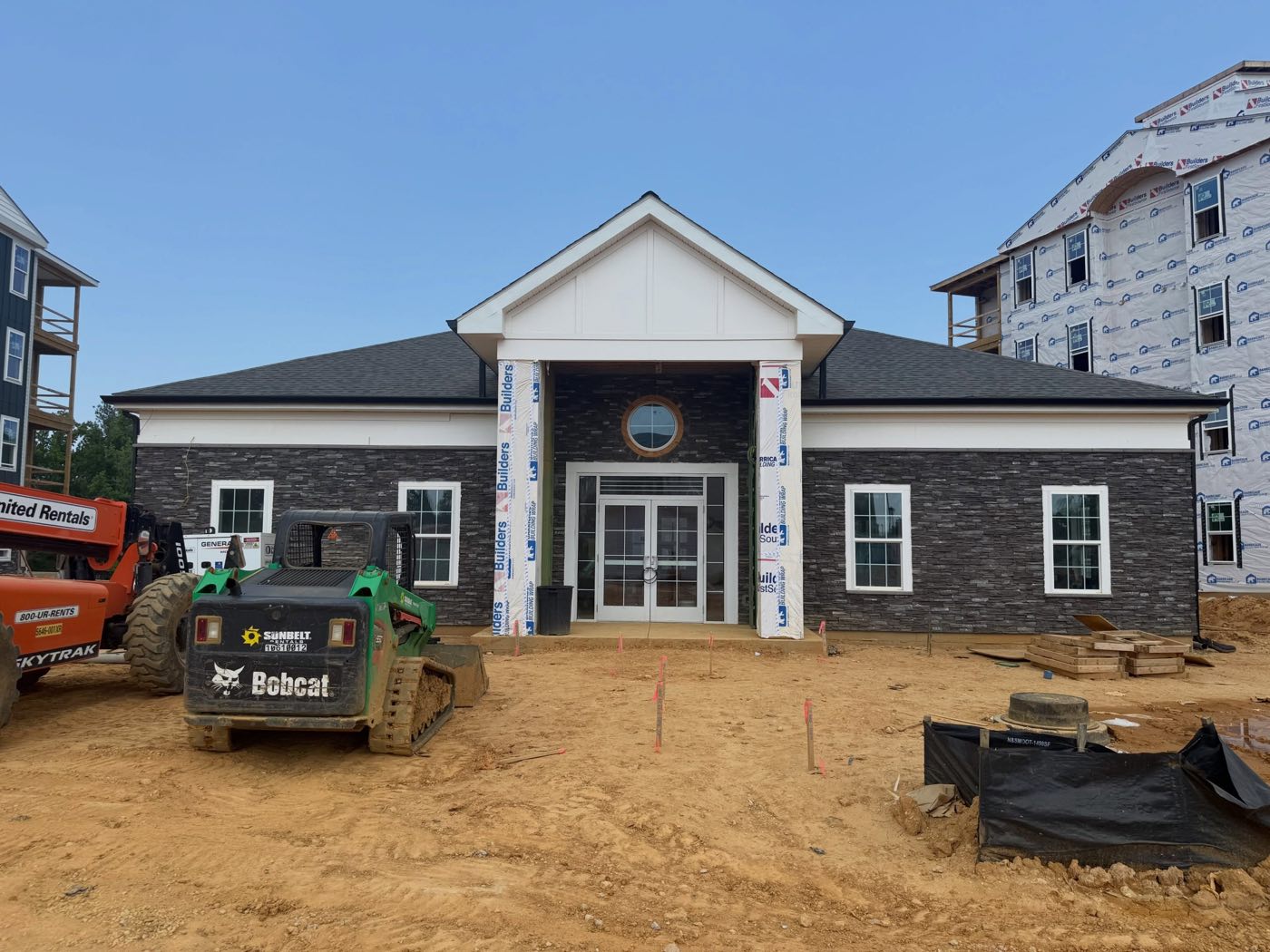 The clubhouse at The Simmons under construction, with stone veneer and a covered entry
