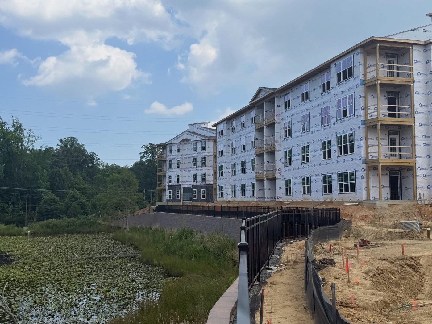 Residential buildings under framing at The Simmons overlooking a pond